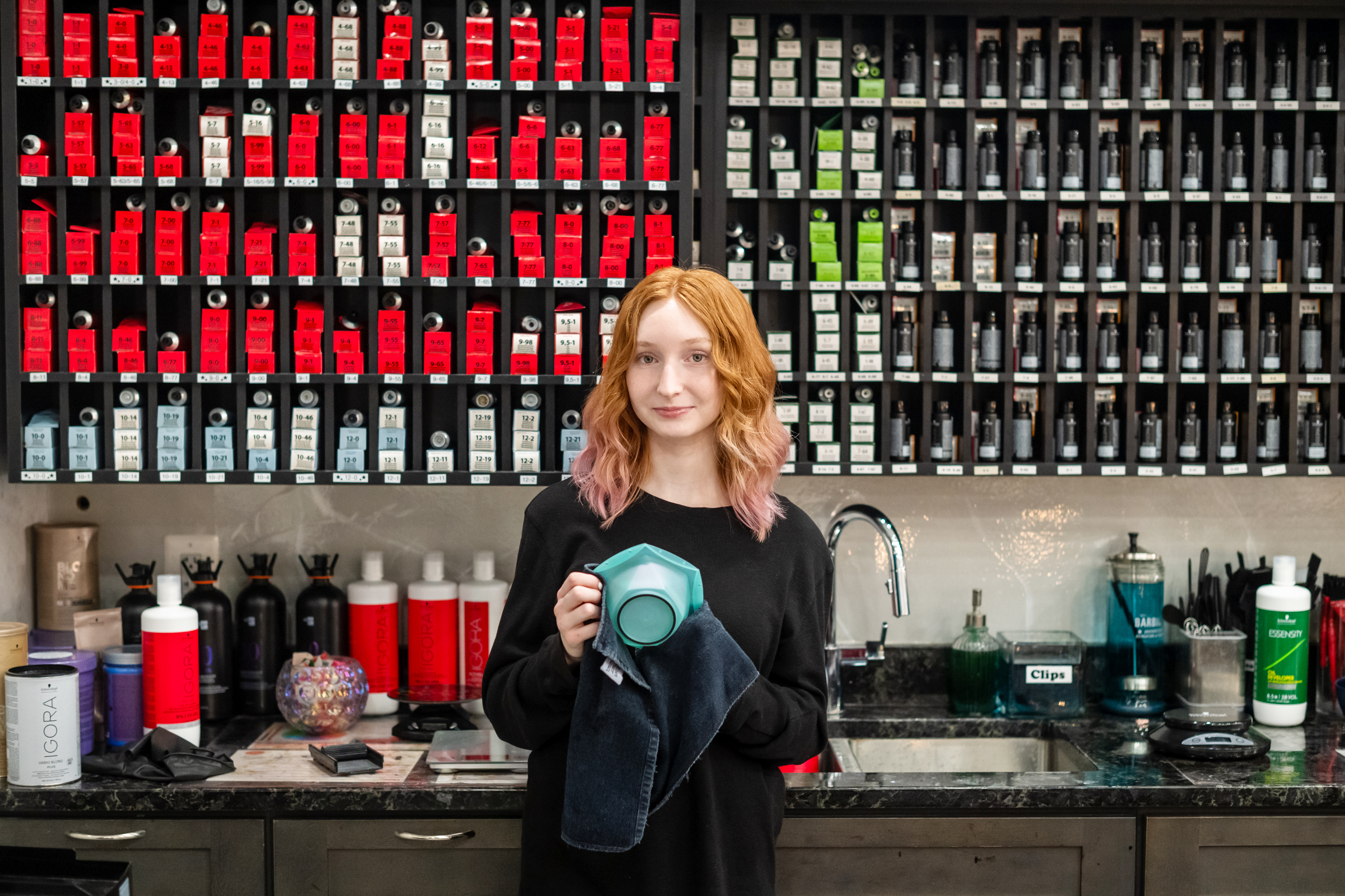 A Cedar Lane student interning at Alya Salon in Vienna stands in front of the hair color bar during her internship.